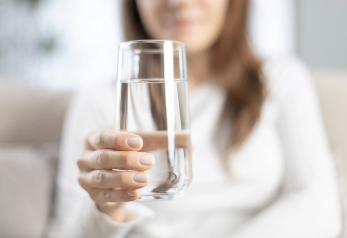 woman holding a fresh glass of water that came from a filtration system in sarasota
