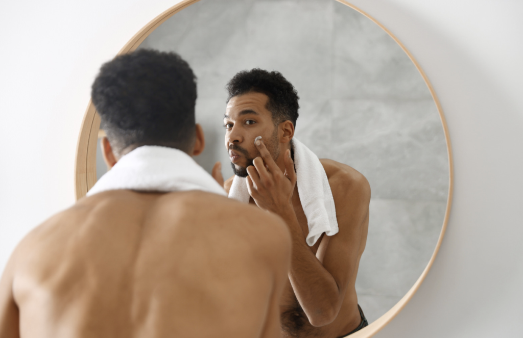 man applying lotion to dry skin on face in sarasota